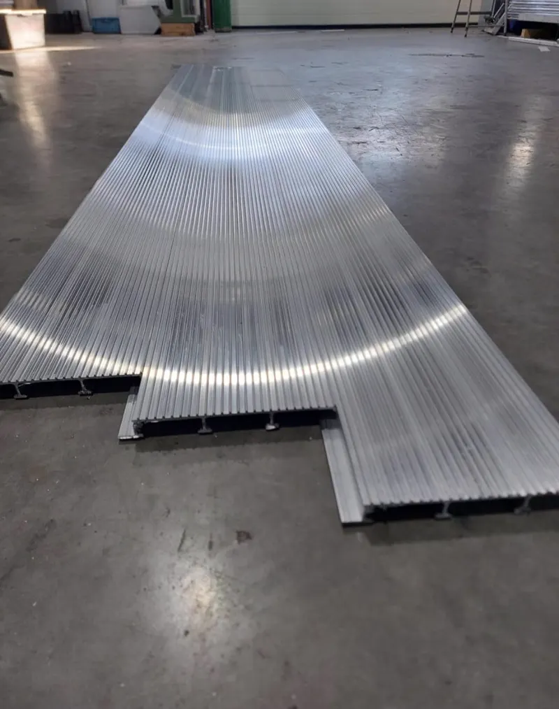 Lange aluminium plank op de vloer van de werkplaats, doorsnede op de voorgrond