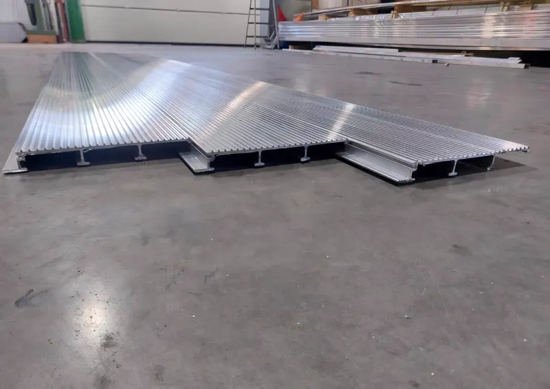 Drie aluminium planken op de vloer met het ribbelprofiel en de doorsnede goed zichtbaar