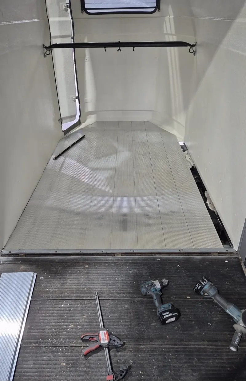 Aluminium vloer tijdens installatie, met accuboormachine en klem op de vloer