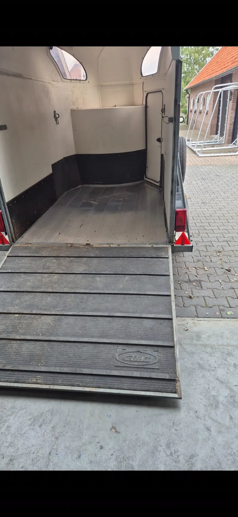 Paardentrailer met geopende deuren en neergeklapte rubberen oprijplaat