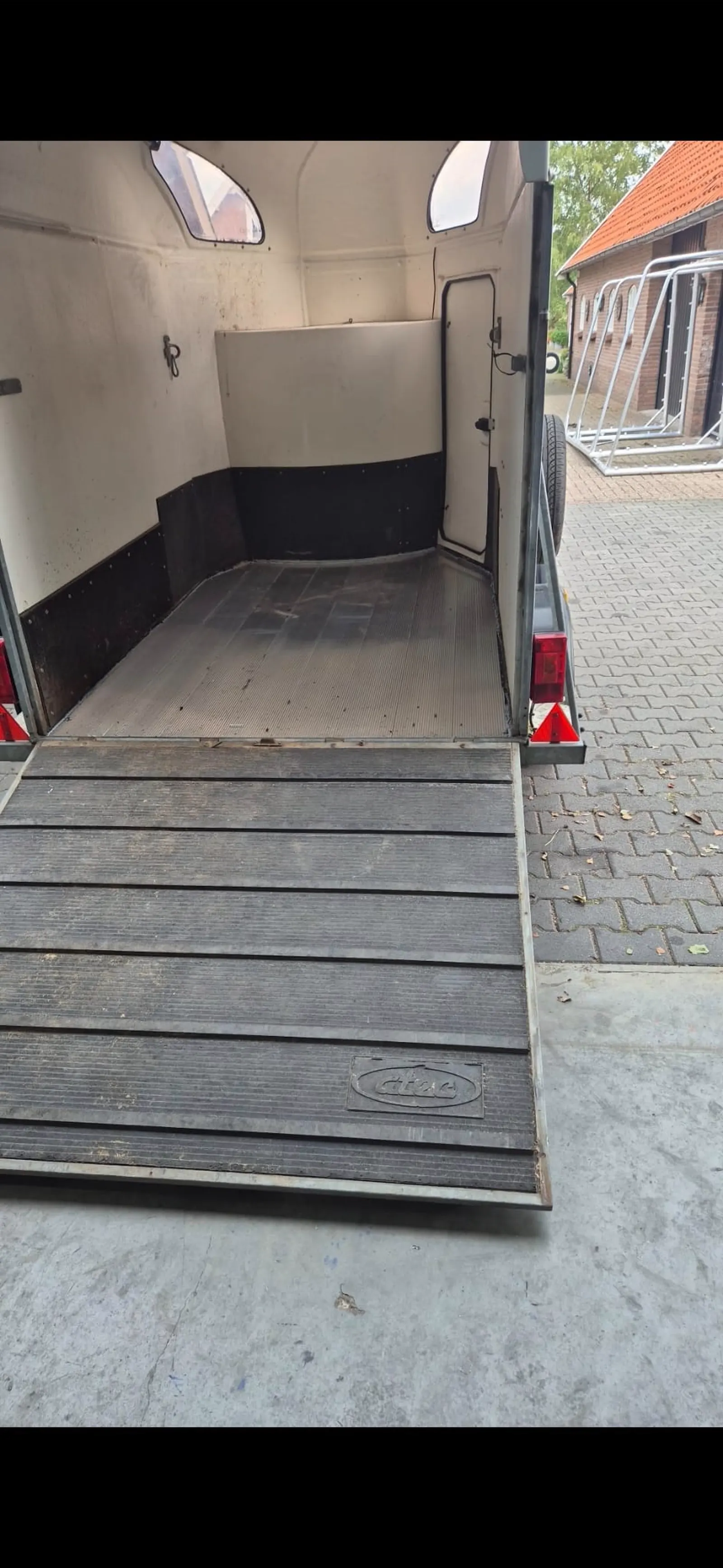 Paardentrailer met geopende deuren en neergeklapte rubberen oprijplaat