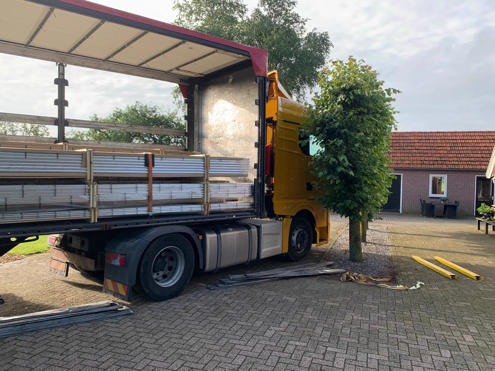 Vrachtwagen levert aluminium profielen bij een boerderij