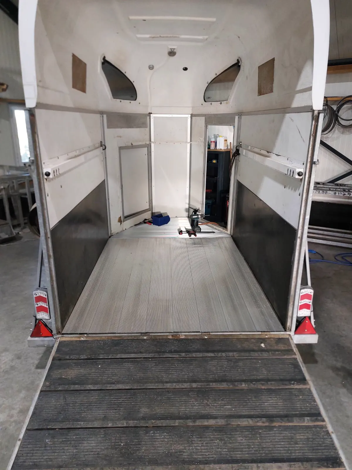 Afgewerkte aluminium bodem in een paardentrailer, deuren open