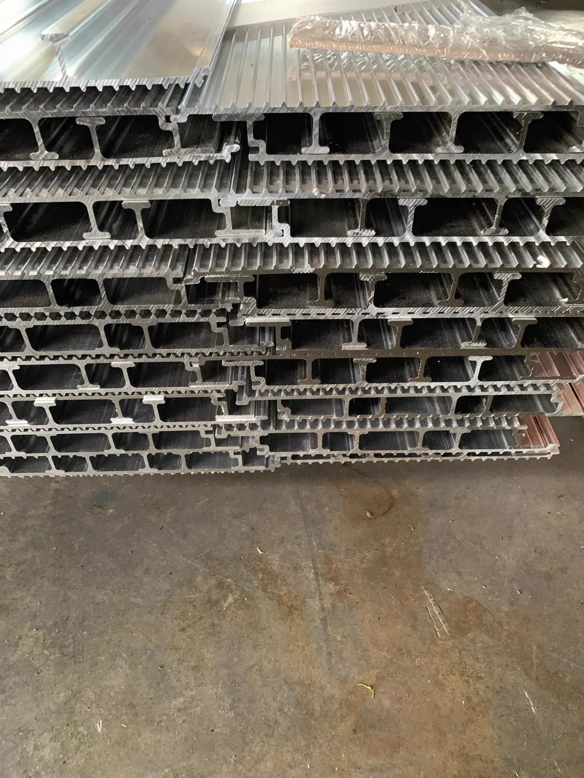 Stapel aluminium profielen met de doorsnede en ribbelpatroon zichtbaar